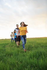 Group of people running in the grass,