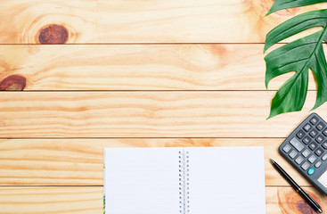 Top view of pen with calculator and notebook on wooden table and copy space for insert text.