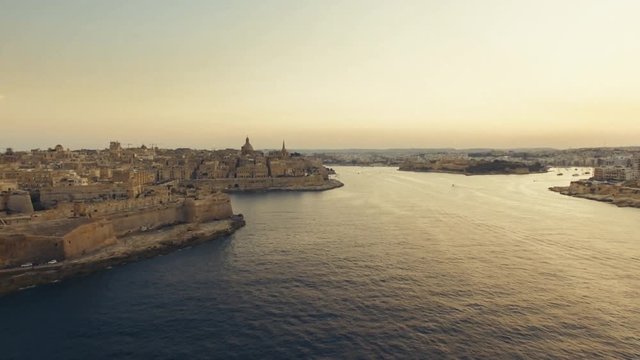 Drone flying backwards in Valletta at Sunset