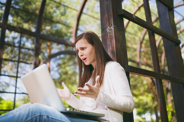 Young successful businesswoman in light casual clothes. Shocked Woman working on modern laptop pc...