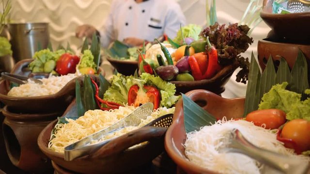 Noodles corner buffet with vegwtables, chef cooking with fire