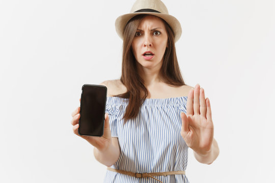Young woman showing stop gesture with palm, showing to camera mobile phone with blank black empty screen isolated on white background. People sincere emotions concept. Advertising area. Copy space.