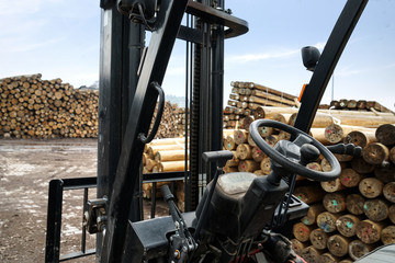 Forklift truck grabs wood in a wood processing plant     