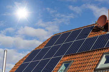 Fototapeta premium Solar panels on a house roof as a source of clean renewable energy.