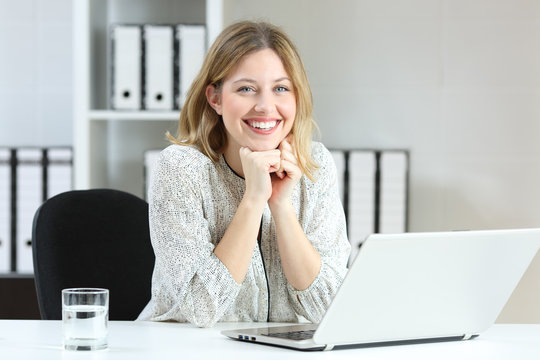 Satisfied employee looking at camera at office