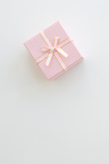 Pink gift or present box on table from above.