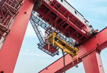 Fototapeta premium The crane is hoisting containers at the wharf