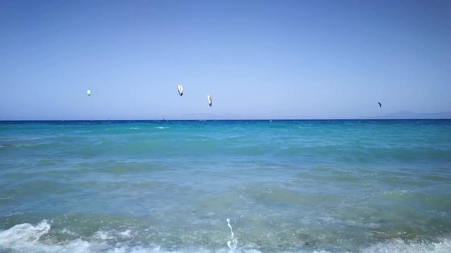 Many people come to coast of Greek island of Rhodes practice kitesurfing enjoying waves by wind and sunshine