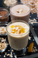 milkshakes with chocolate and mango in glasses, vertical