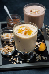 milkshakes with chocolate, oatmeal and mango in glasses, vertical