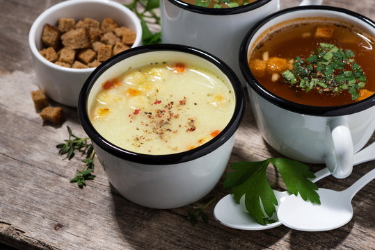 hot soups in mugs on wooden table