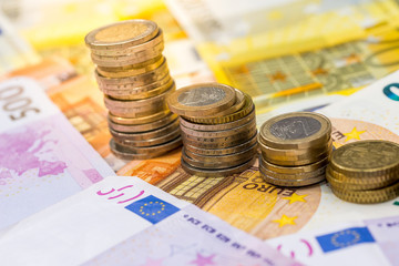 Euro coins on euro banknotes as background