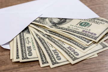 dollar in envelope on desk. savings concept.