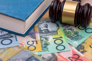 Judge's gavel and book on australian dollar background