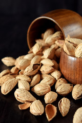 Unpeeled almond nuts in wooden bowls