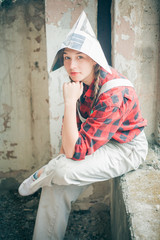 Portrait of young beautiful woman in newspaper hat. Repair home concept.