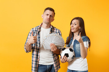 Young win couple, woman man, football fans holding bundle of dollars, cash money, soccer ball,...