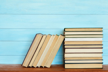 Stack of colorful books. Books on wooden table.