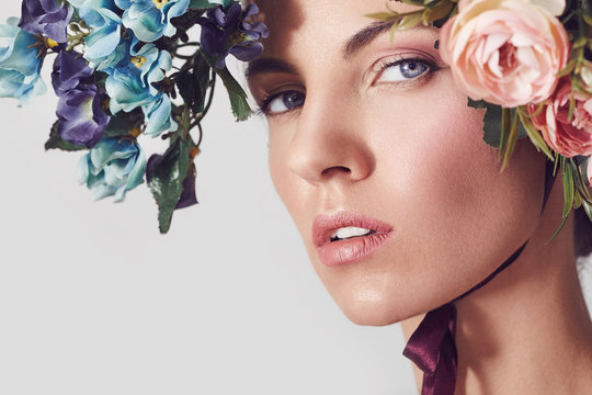 A portrait of a young beautiful woman with flowers on the head. Spring fashion photo. Skin care concept, beauty spa, bio product. 