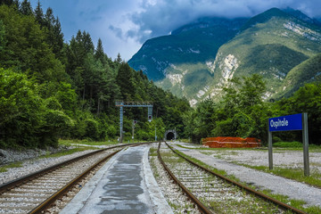 Fototapeta premium Ospitale, Italy - July, 12, 2018: Alpine landscape with the image of mountain railroad and Ospitale train station