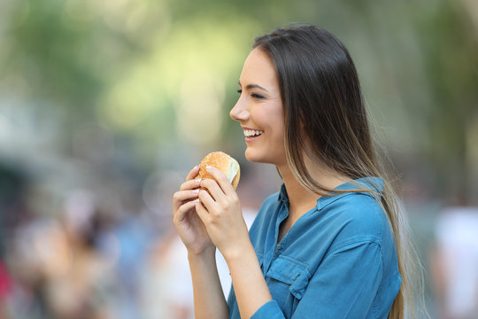 Profile of a woman holding a burger