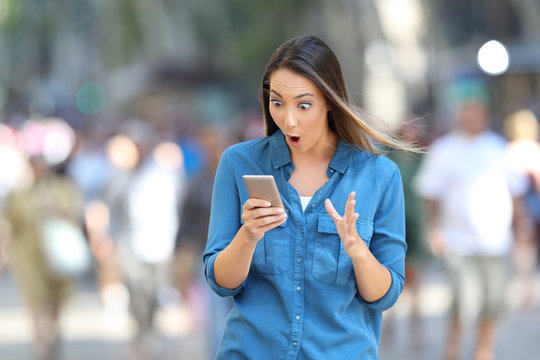 Shocked woman reading smart phone messages
