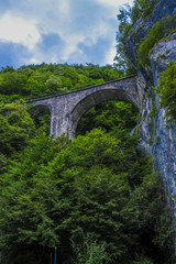 Fototapeta na wymiar Alpine landscape with the image of arch bridge