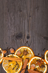 Christmas background: dried orange, cinamon, hazelnut, anise and cloves on dark brown wooden plank, copy space