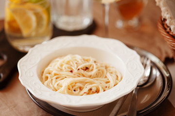 Lunch meal pasta with cream sauce, served with glass of white wine