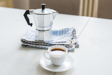 Vintage coffee pot, a cup of coffee is on a white table