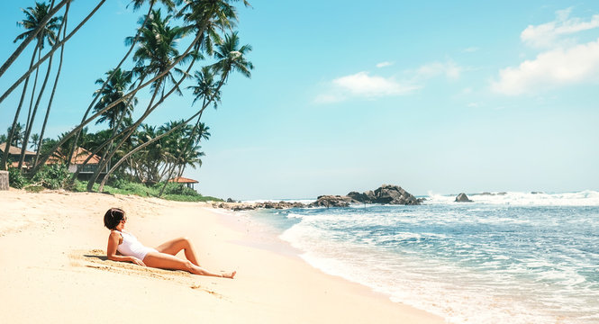 Woman takes sunbath on tropical beach