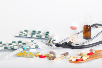 Stethoscope with various medicines, pills, ampules and syringes isolated on a white background. Health concept.Drugs in hospital or pharmacy.