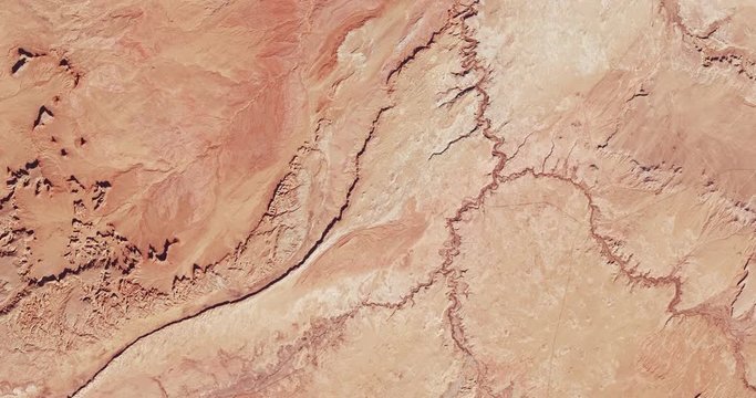 Very high-altitude overflight aerial of rocky desert, Monument Valley, Arizona and Utah. Clip loops and is reversible. Elements of this image furnished by USGS/NASA Landsat