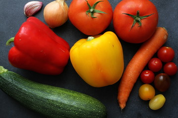 Variety of fresh vegetables on dark board, top view