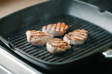 Close up preparation of pork fillet in a frying pan.