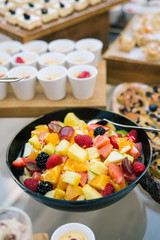 Fruit salad served in black bowl during buffet.
