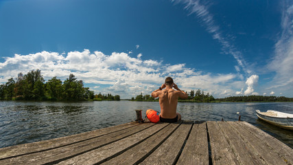 Fitness man goes swimming, jetty, boat, drybag and goggles © DZiegler