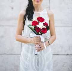 Wedding bride holding a bouquet of roses.