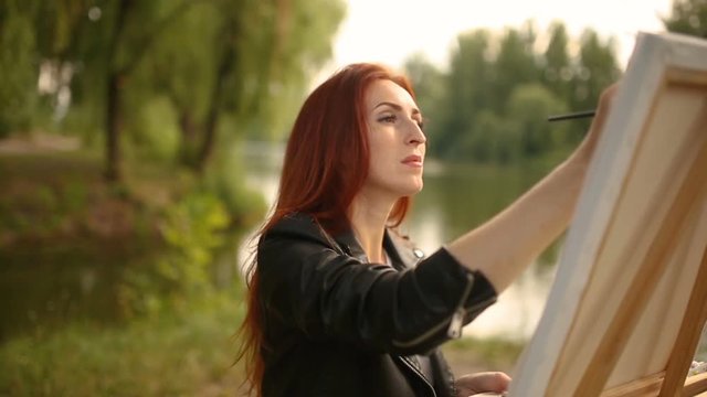 Young woman artist creating landscape working outdoor by the lake