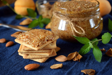 Urbech of apricot kernels in a glass jar and on a cracker