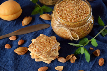 Urbech of apricot kernels in a glass jar and on a cracker