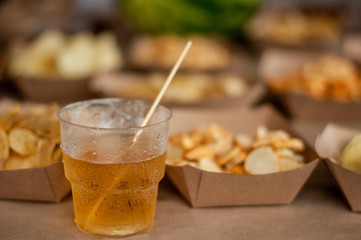 Cool drink of cider, beer, lemonade, in a glass on wooden rustic snacks background. Alcoholic drink concept.  Сlose-up, space for text, soft selective focus