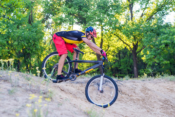 Naklejka premium Сoncept of an active lifestyle, a cyclist riding a mountain bike, a bright summer photo.