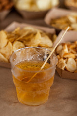Cool drink of cider, beer, lemonade, in a glass on wooden rustic snacks background. Alcoholic drink concept.  Сlose-up, space for text, soft selective focus
