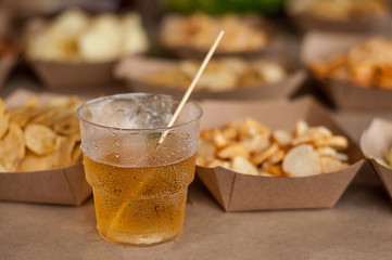 Cool drink of cider, beer, lemonade, in a glass on wooden rustic snacks background. Alcoholic drink concept.  Сlose-up, space for text, soft selective focus