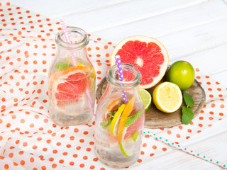 Infused flavored water with fresh fruits on white wooden background.Refreshing summer homemade  detox water