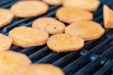 Close up view on sweet potatoe slices on the grill