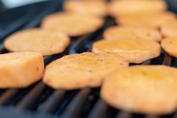 Close up view on sweet potatoe slices on the grill