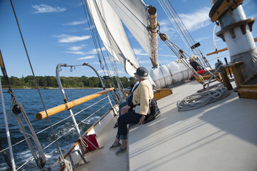 Naklejka premium Schooner Sailboat Heeling from Wind Gust As Tourists Hold On