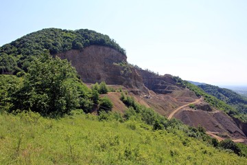 Green hill devastated. Open pit mine for extracting stone. 